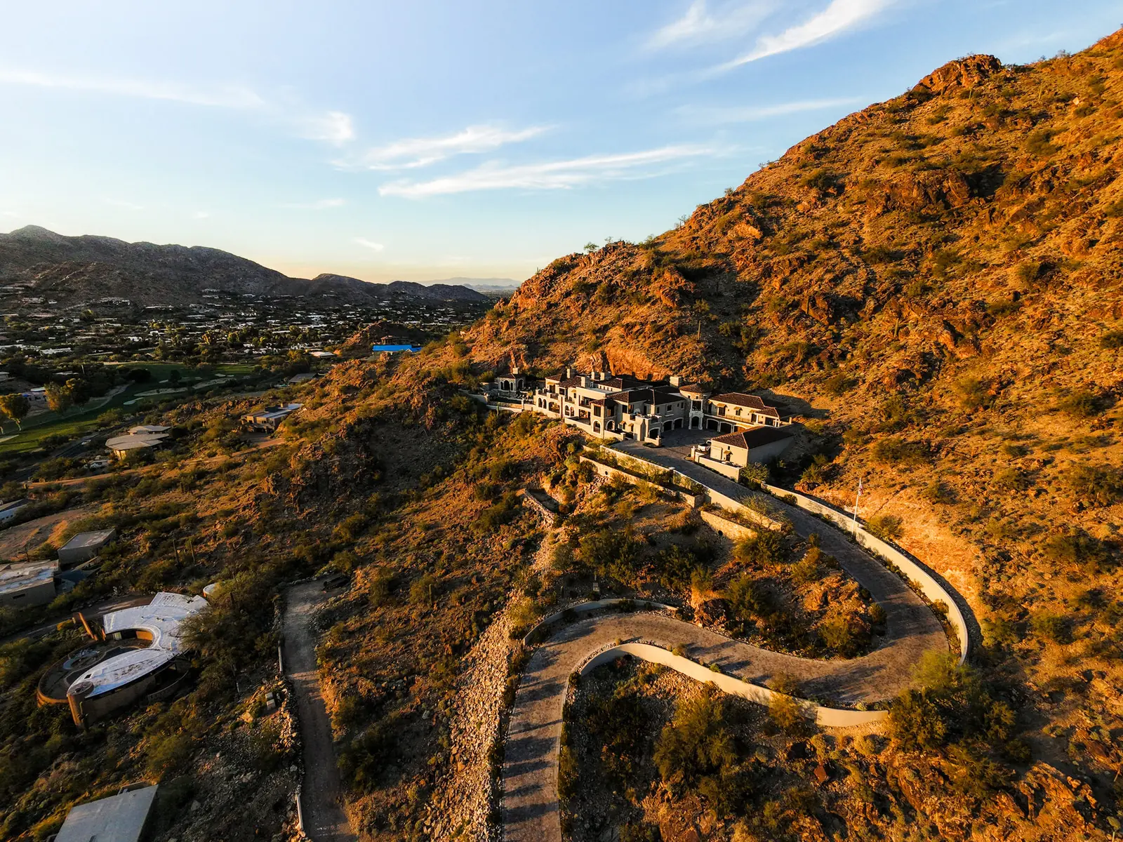 Hillside estate on a desert ridge at sunrise with switchback access road